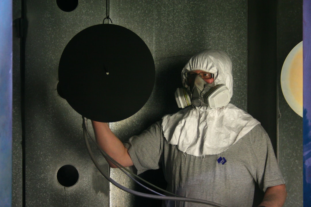Spray gun applying an even sublimation coating in an industrial spray booth